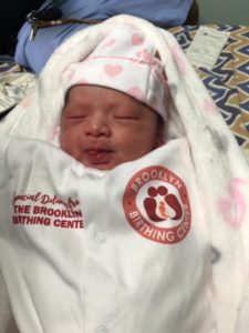 a newborn in a Brooklyn Birthing Center onesie