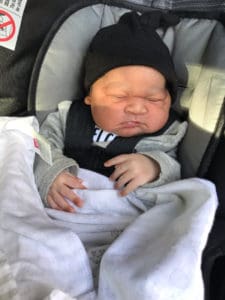 a male newborn in a car seat